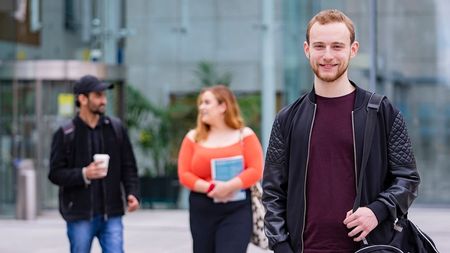 male student at college with other students in the background