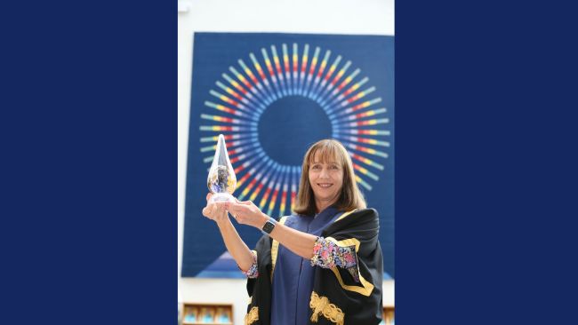 NCI President Gina Quin holding the Athena SWAN award